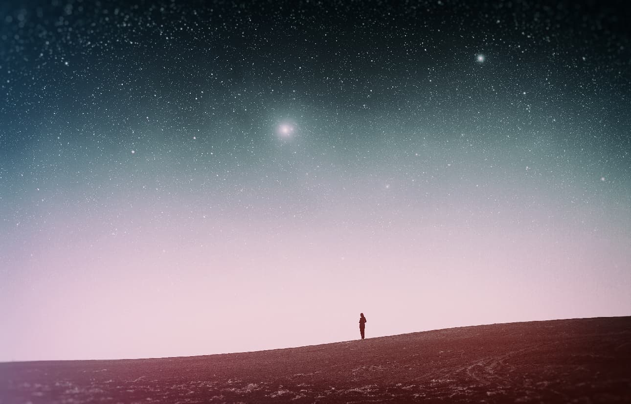 Scenic picture at dusk of sky with stars and person on ground