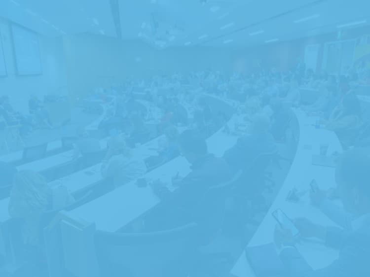 a conference room filled with people sitting at tables